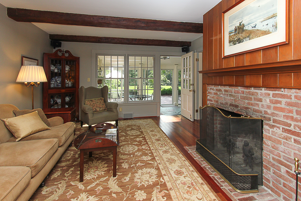 Fireplace in the den and door out to the sun room at 743 Bay Road Hamilton Massachusetts